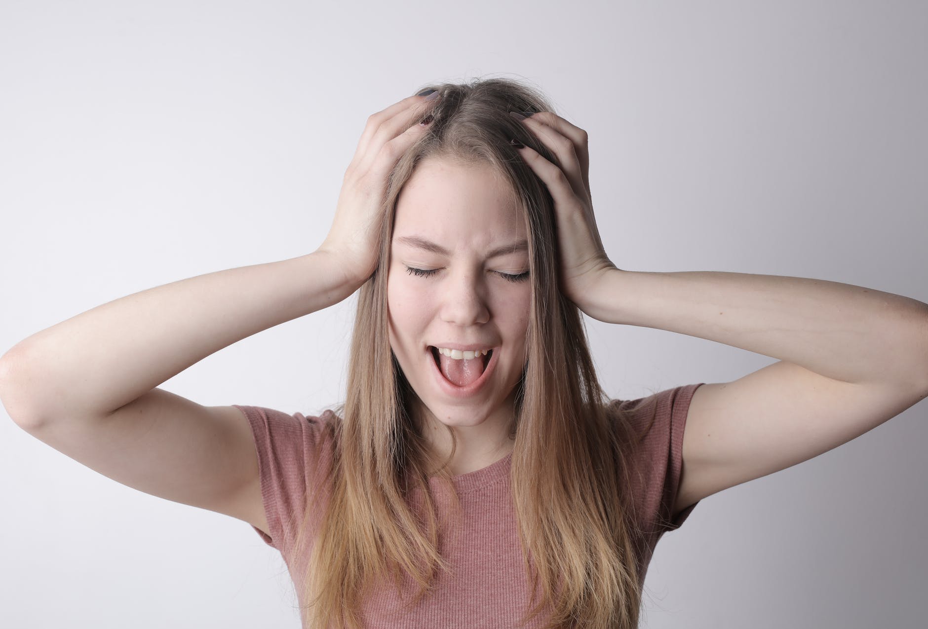 young frustrated woman screaming with closed eyes